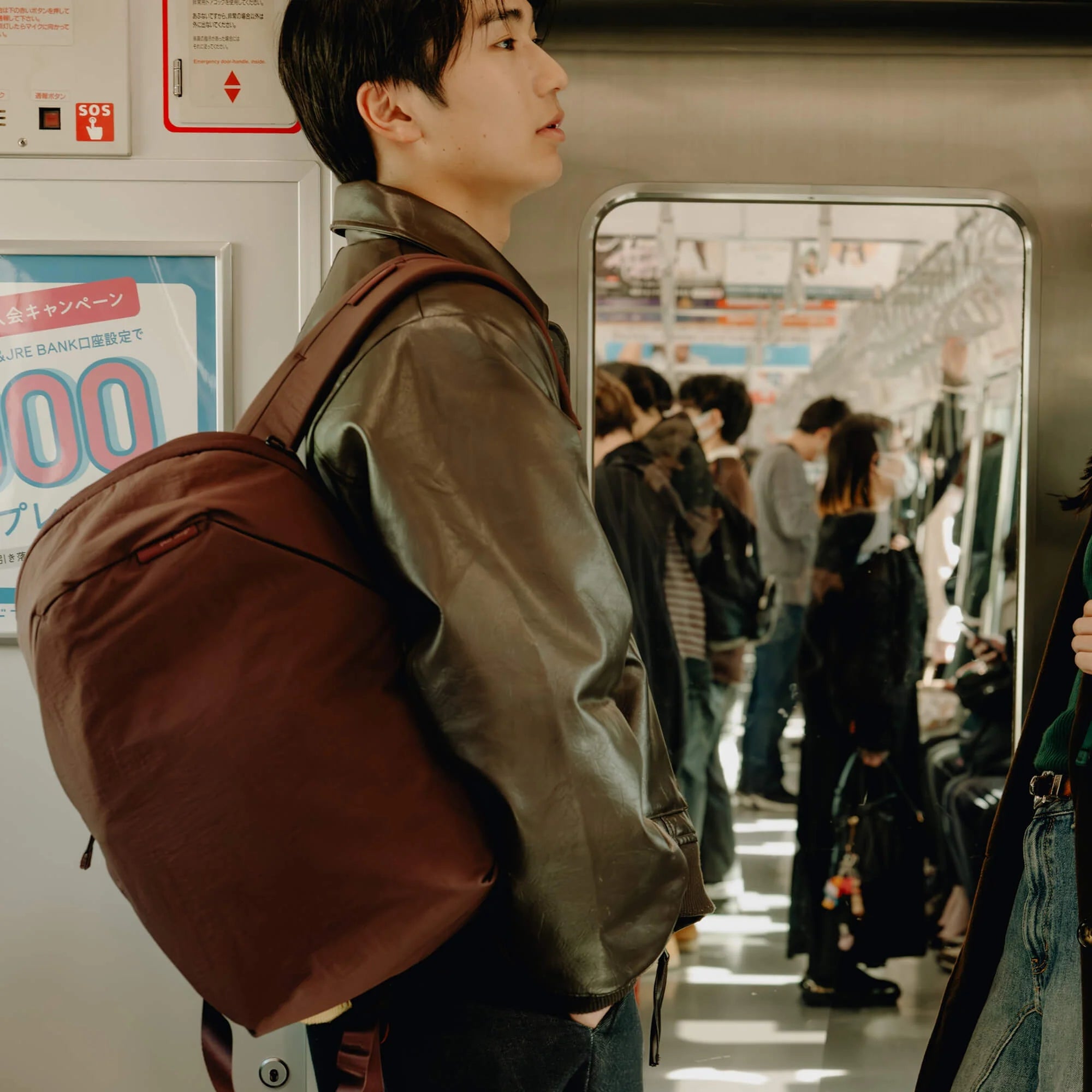 Man carrying a City Line Backpack inside a train image