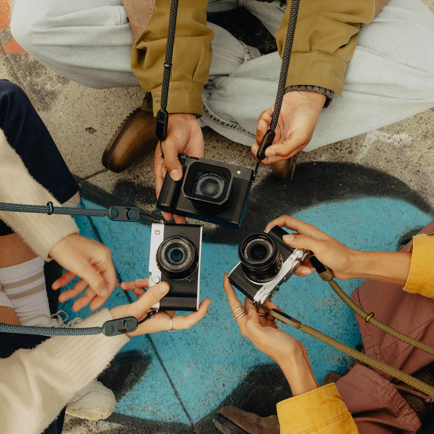Three cameras with straps attached to them